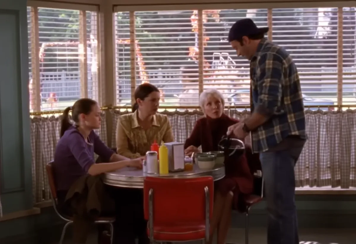 Rory e Lorelai sentadas com Mia no Luke's Diner na segunda temporada de 'Gilmore Girls'